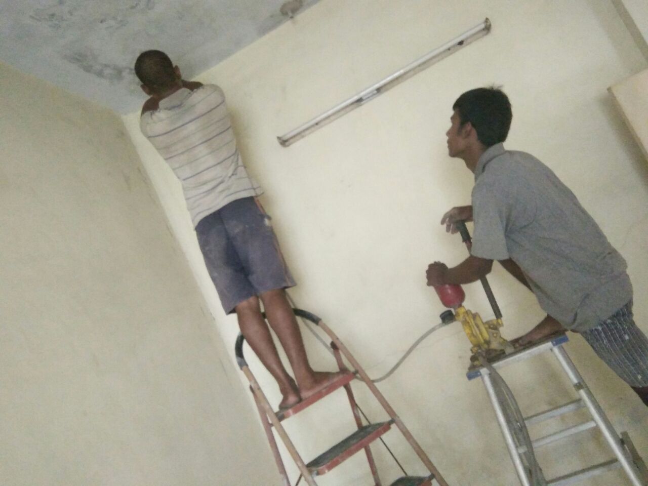 Two-person crew treating a ceiling